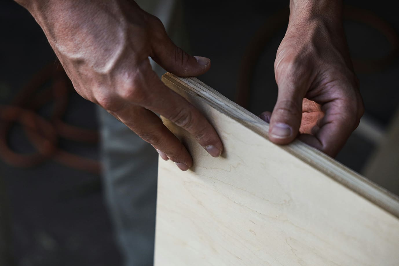 A person cutting wood with a pair of scissors.