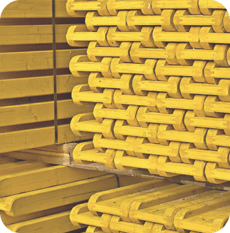 A stack of yellow pipes in the middle of stacks.
