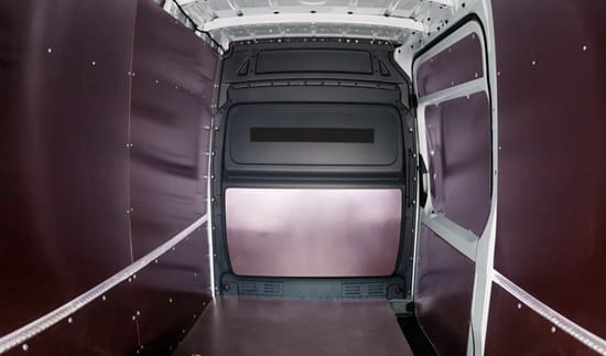 A van with the door open and its interior being cleaned.
